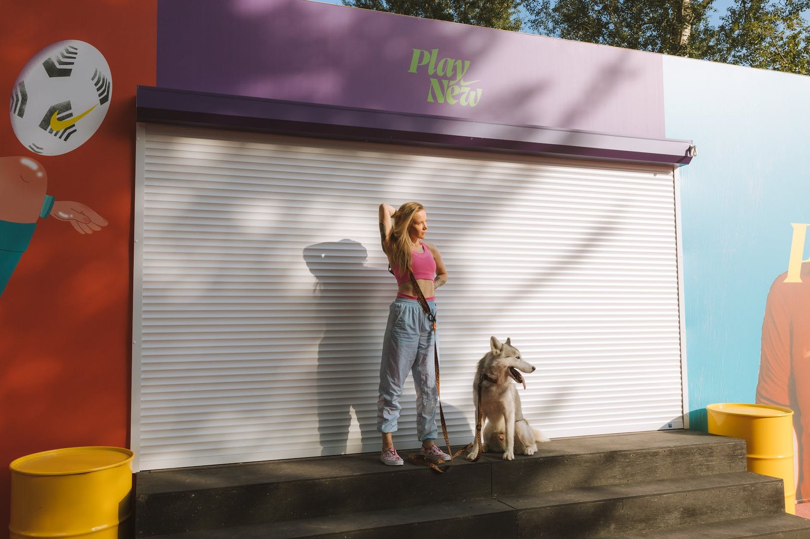 woman in pink tank top with her dog standing near shutter